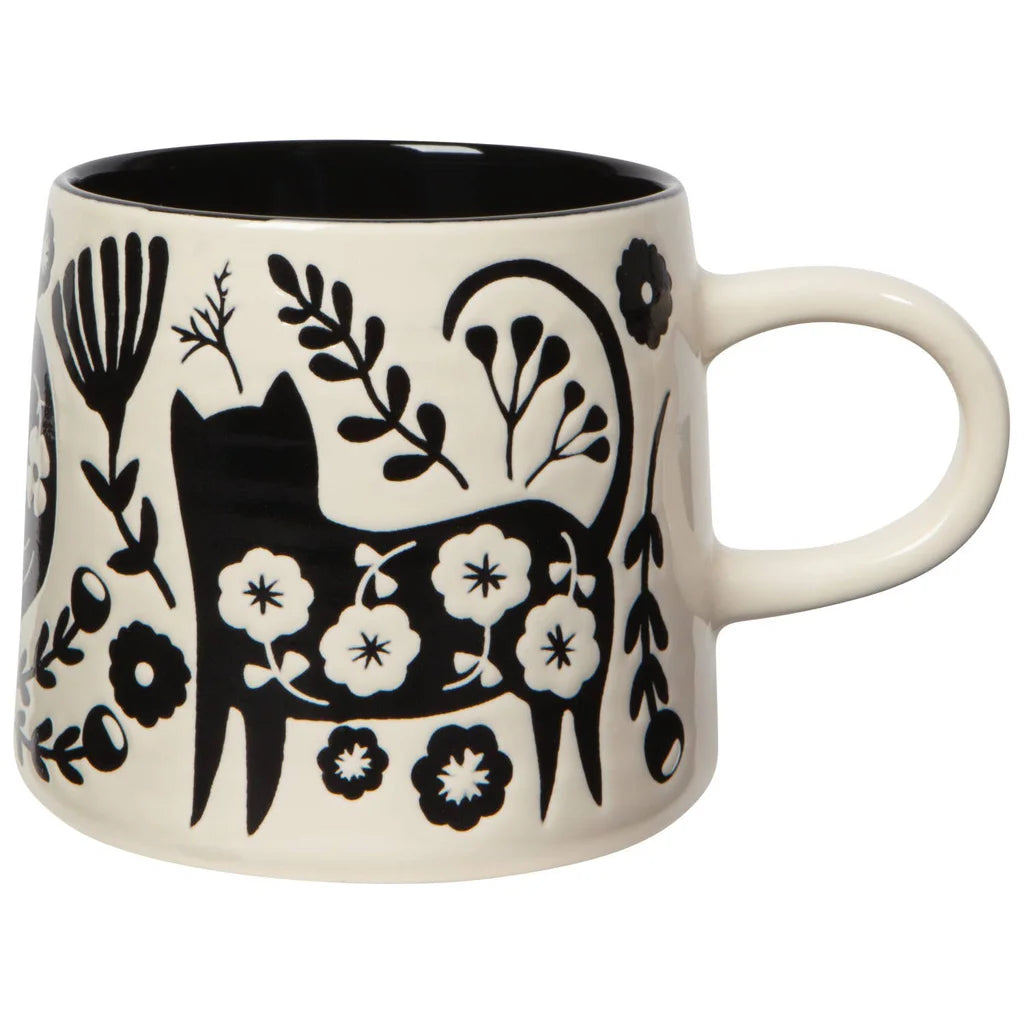White mug with black floral and cat design on a white background