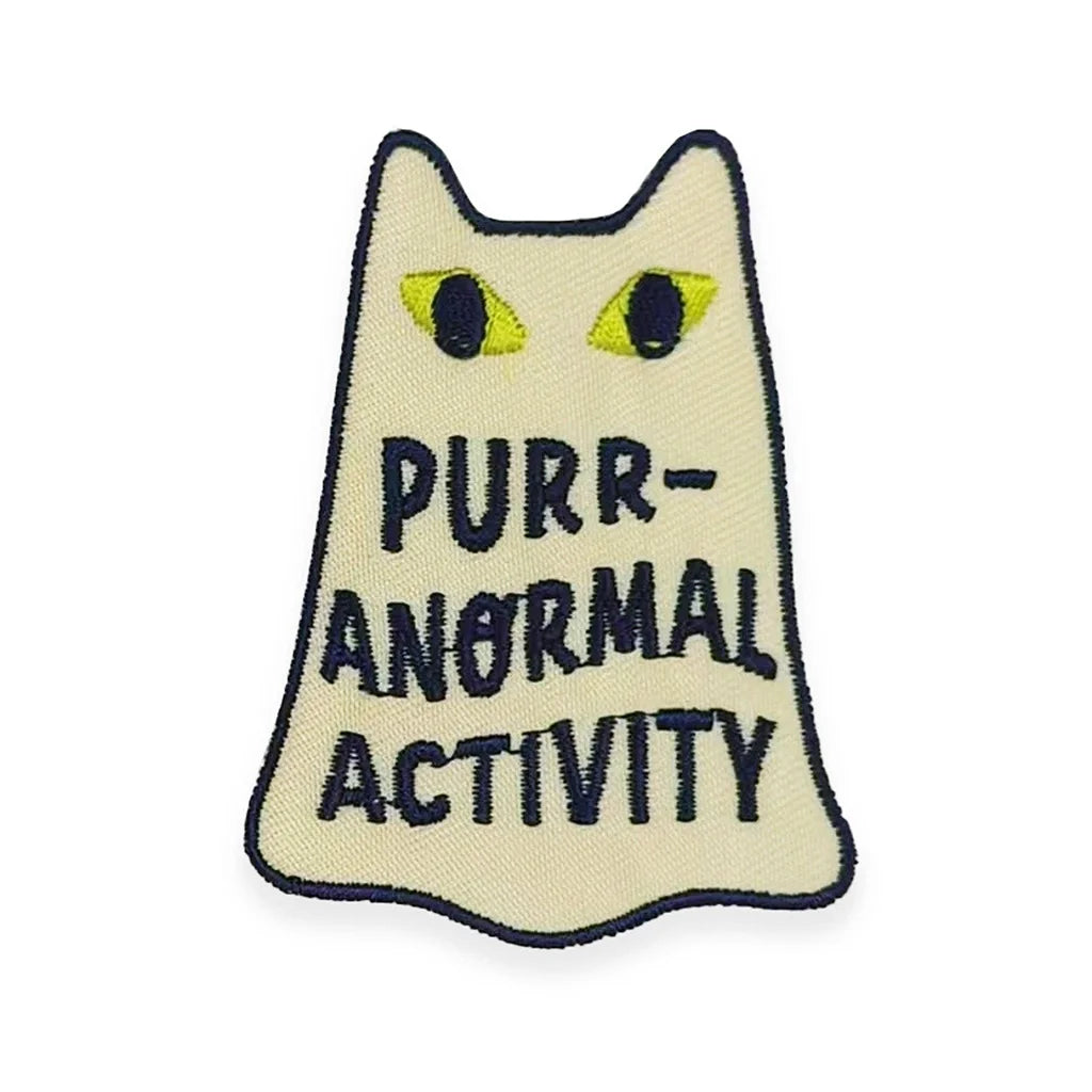 Embroidered patch of a cat ghost design and text 'Purr-Anormal Activity' on a beige background.