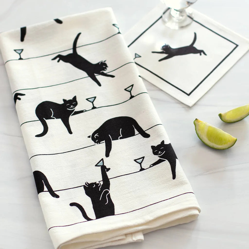 Tea towel with black cat and martini glass illustrations on a white background