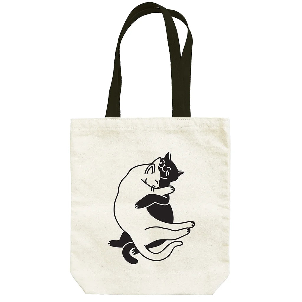 Tote bag with two black and white cats snuggling illustration on a white background