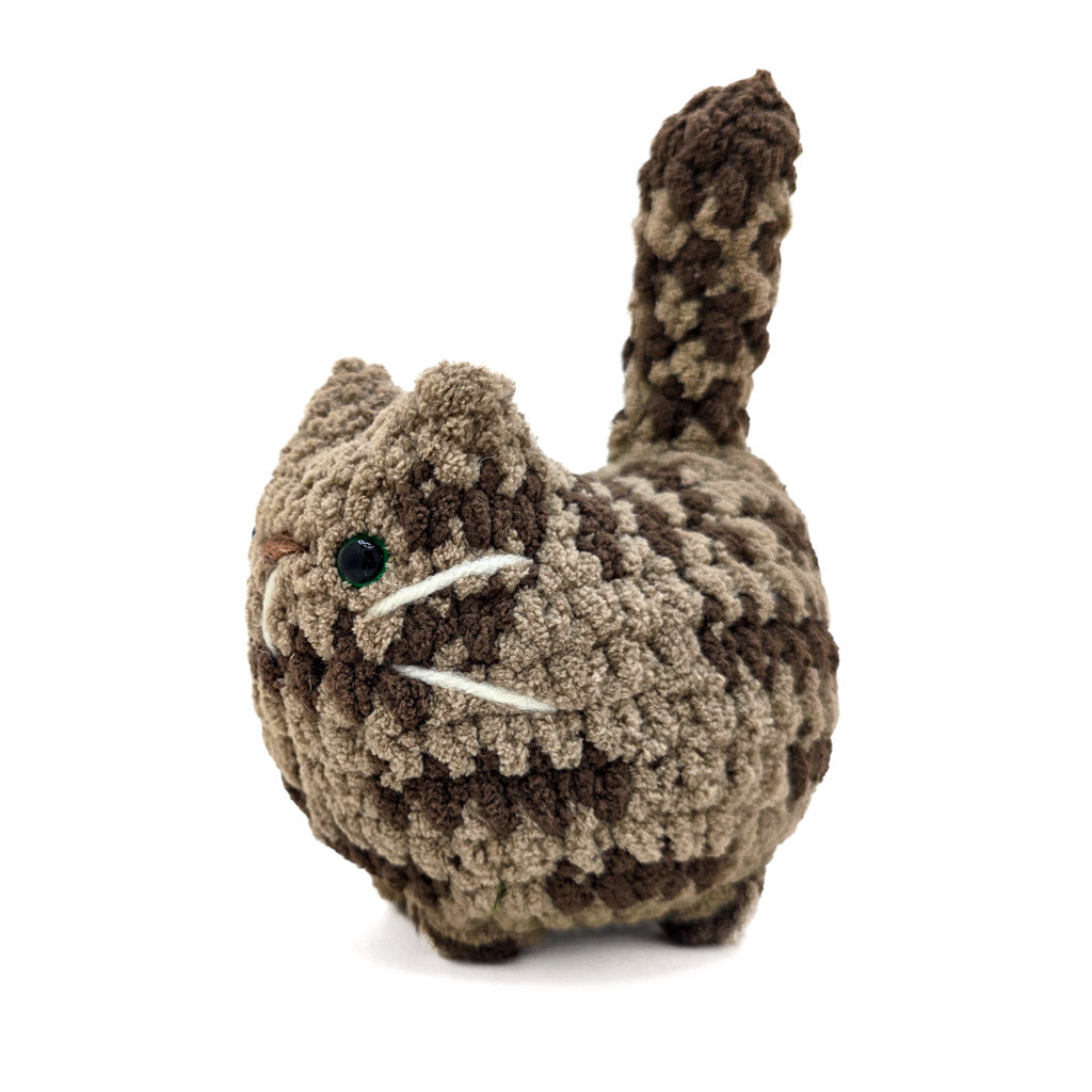 A hand-crocheted brown tabby cat plush toy made with soft yarn.